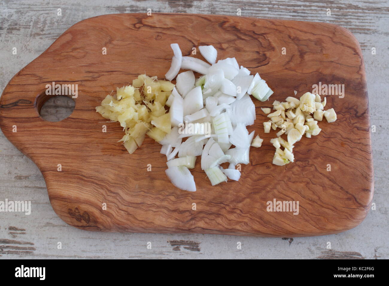 Oignons hachés, le gingembre et l'ail sur une planche à découper en bois d'olive. étape par étape de la cuisson. Banque D'Images