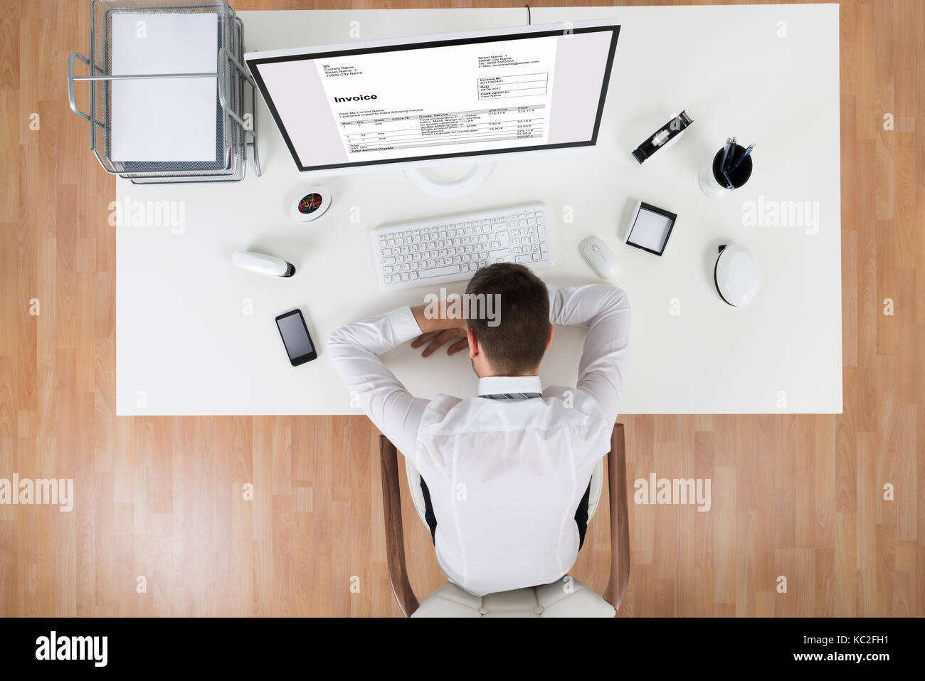 High angle view of young businessman sleeping in front of computer Banque D'Images
