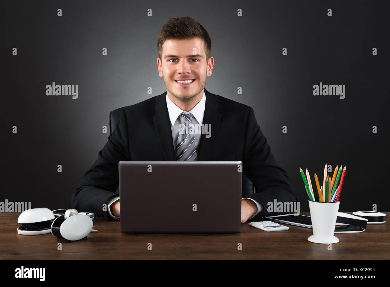 Les jeunes professionnels Businessman Working With Laptop At Desk Banque D'Images