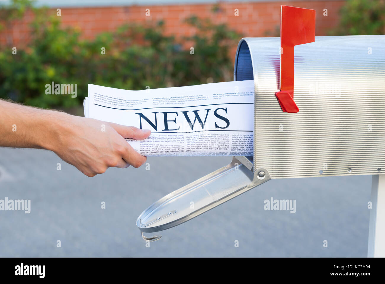 Close-up of personne mains ouvrant sa boîte aux lettres pour retirer le journal Banque D'Images