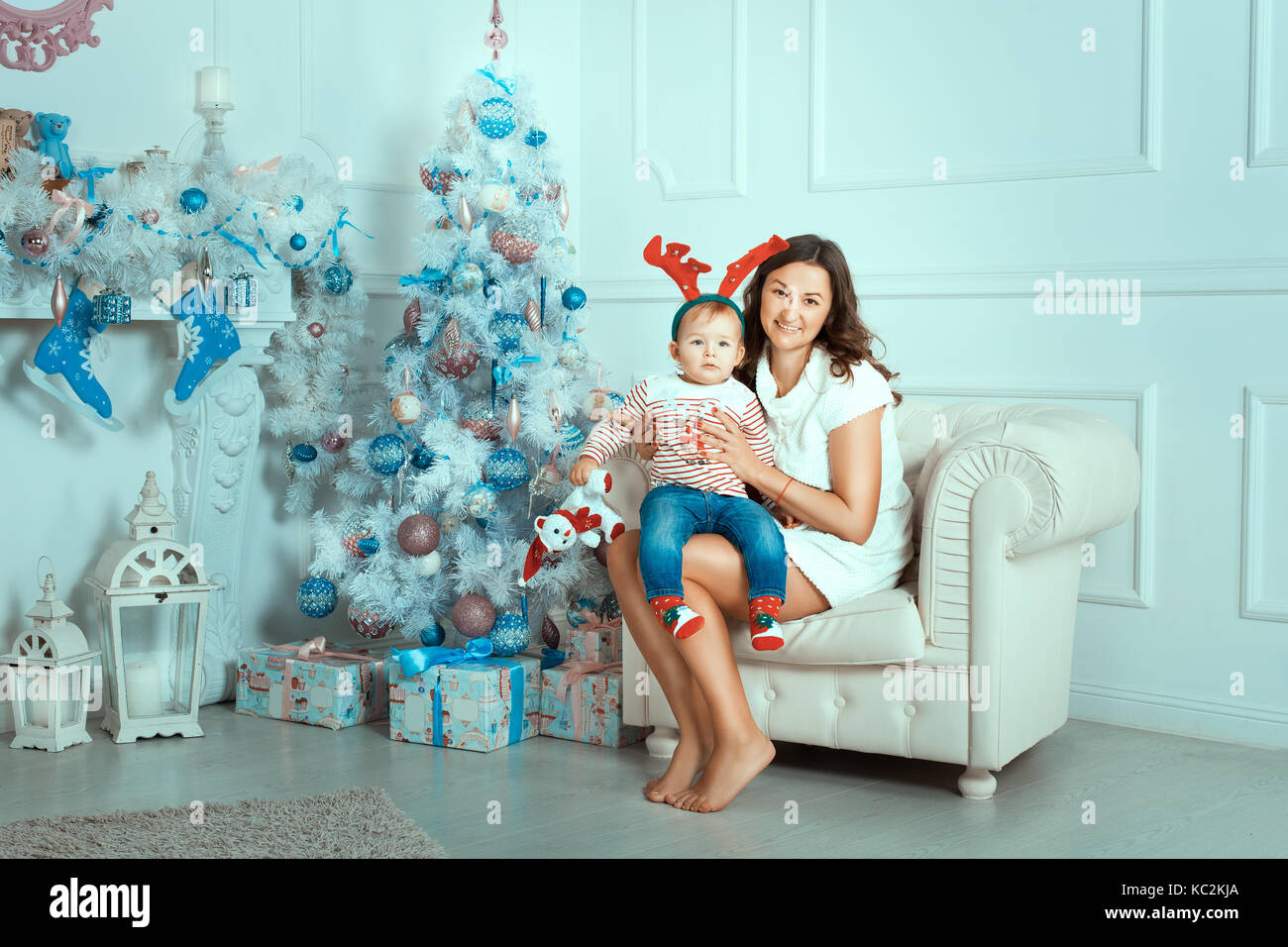 Mère et fille près d'un arbre de Noël. maman garde fille sur les mains Banque D'Images