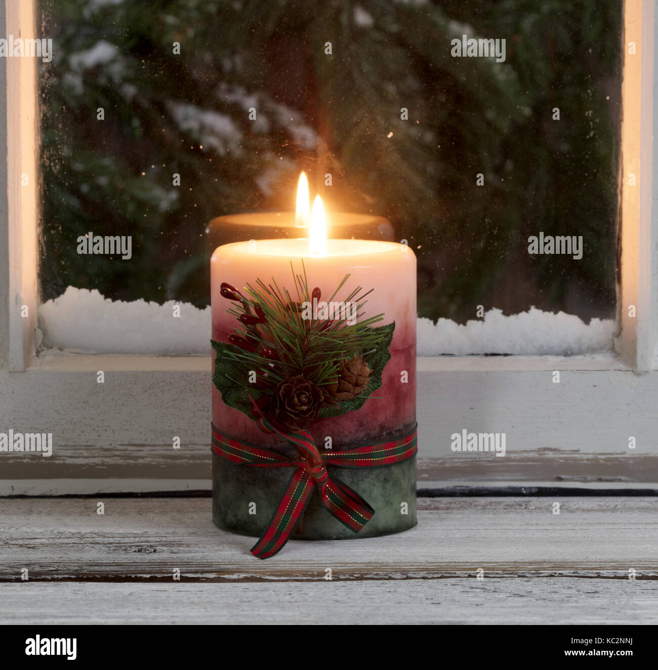 Bougie de Noël allumé sur l'appui de fenêtre avec des branches de conifères  enneigés en arrière-plan Photo Stock - Alamy
