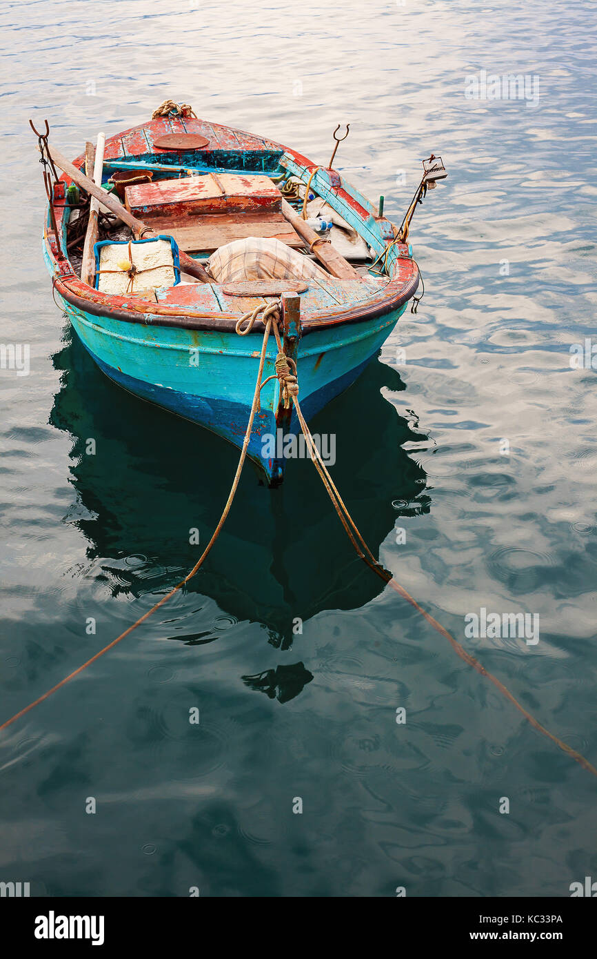 Un vieux bateau de pêche avec filets et d'autres équipements dans l'eau de mer. Banque D'Images