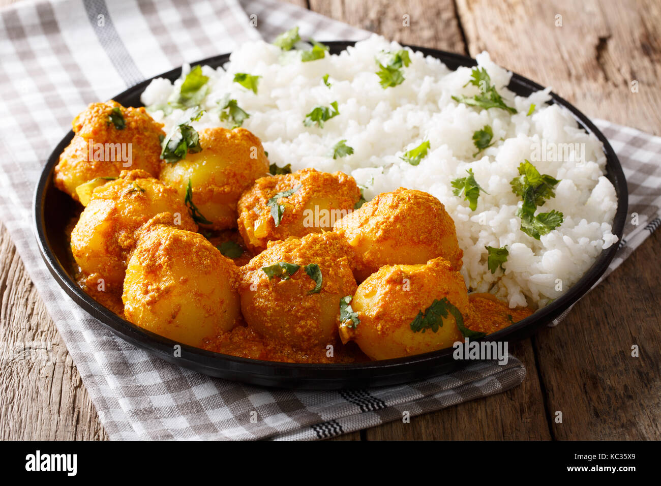 Pommes de terre au curry indien dum aloo en sauce avec du riz sur la table horizontale. Banque D'Images