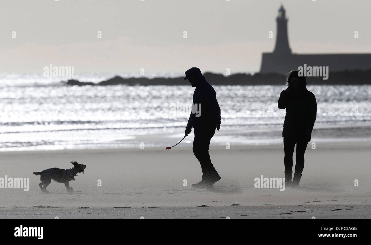 Les promeneurs de chiens sur une plage de tynemouth exposée au vent comme des vents violents balaient l'ensemble du Royaume-Uni. Banque D'Images