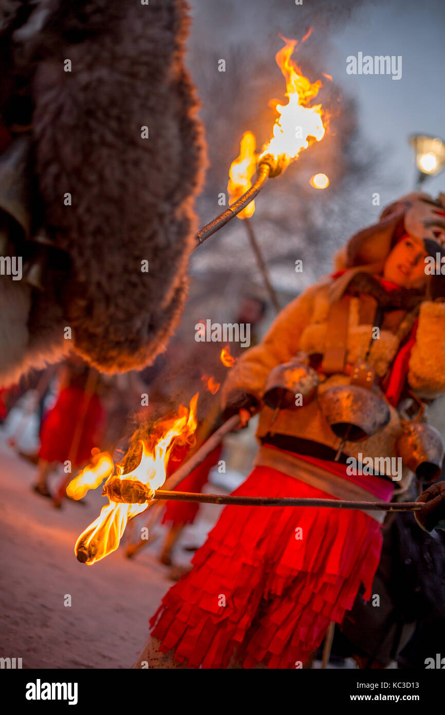 Pernik, Bulgarie - 27 janvier 2017 : les participants masqués dans scary costumes de fourrure passent le feu à l'autre, les torches à surva fest international Banque D'Images