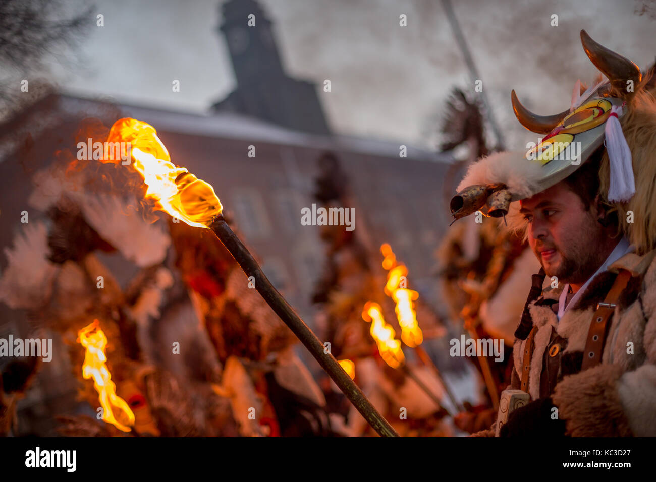 Pernik, Bulgarie - 27 janvier 2017 : participant à la fourrure est effrayant costume holding flambeau ardent et le regarder à l'international, surva fest Banque D'Images