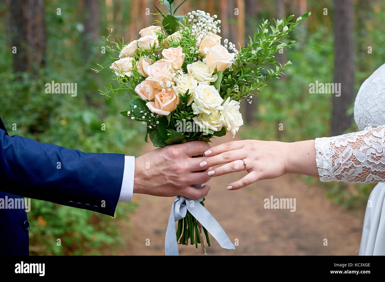 Époux donne à l'épouse un bouquet de mariage pour une promenade dans le parc Banque D'Images