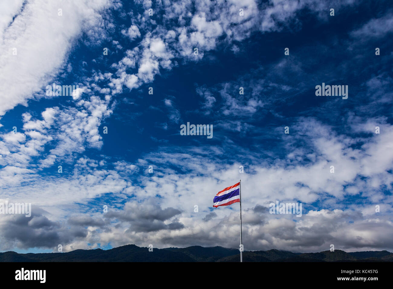 Drapeau national thaïlandais de haut vol sur le poteau contre nuages moelleux et de montagnes, prix pour le texte ou copy space Banque D'Images