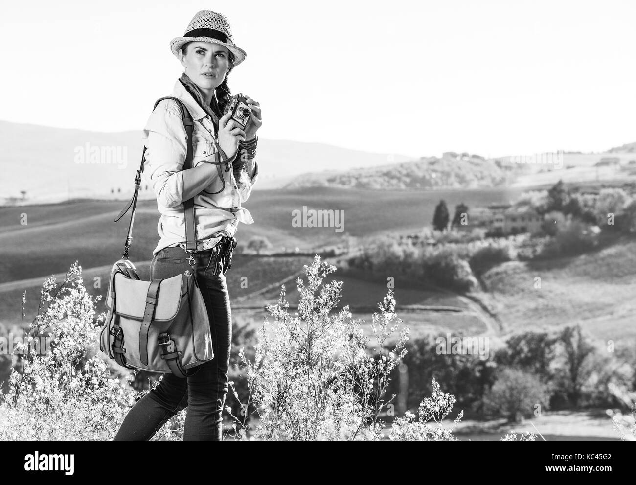 Découvrir une vue magique de la toscane. femme active avec sac Randonneur admirant toscane view avec appareil photo vintage Banque D'Images