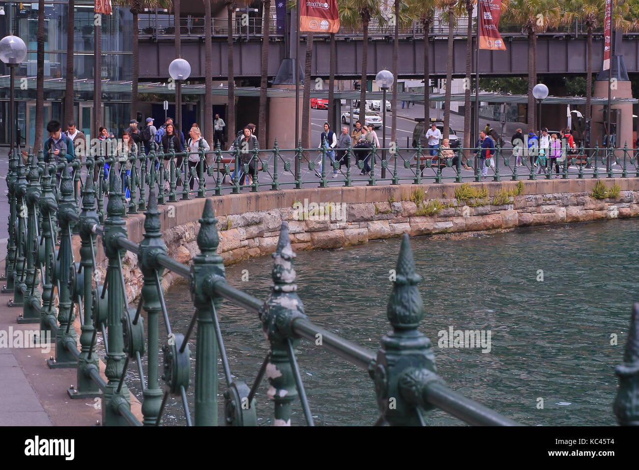 Les personnes qui marchent le long du sentier de Circular Quay en regardant leurs téléphones mobiles Banque D'Images