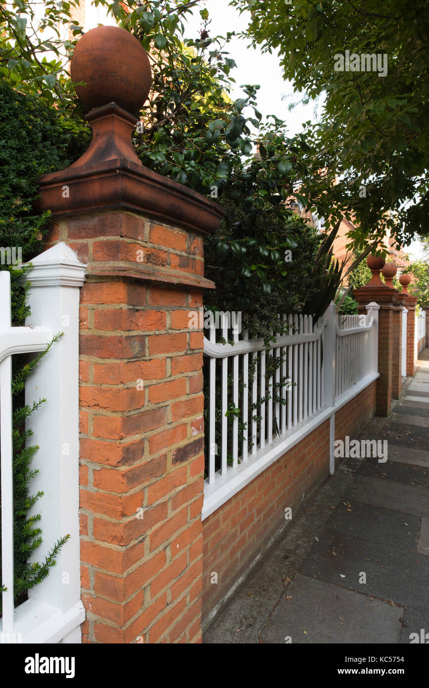 Une balle sur une brique finial pilier et une palissade en bois clôture dans le Queen Anne's Grove, Bedford Park, Chiswick, Londres, UK Banque D'Images