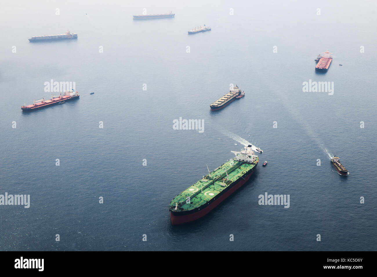 Les navires dans le détroit de Singapour à partir de la hauteur. grande citerne avec deux plates-formes d'hélicoptères rester sur l'ancre et attendre leur tour pour entrer dans le port pour u Banque D'Images