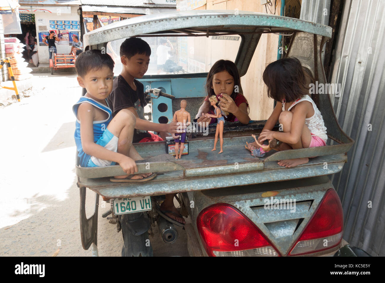 Enfants philippins jouer à la poupée à l'arrière d'un taxi, Cebu City, Cebu, Philippines Banque D'Images