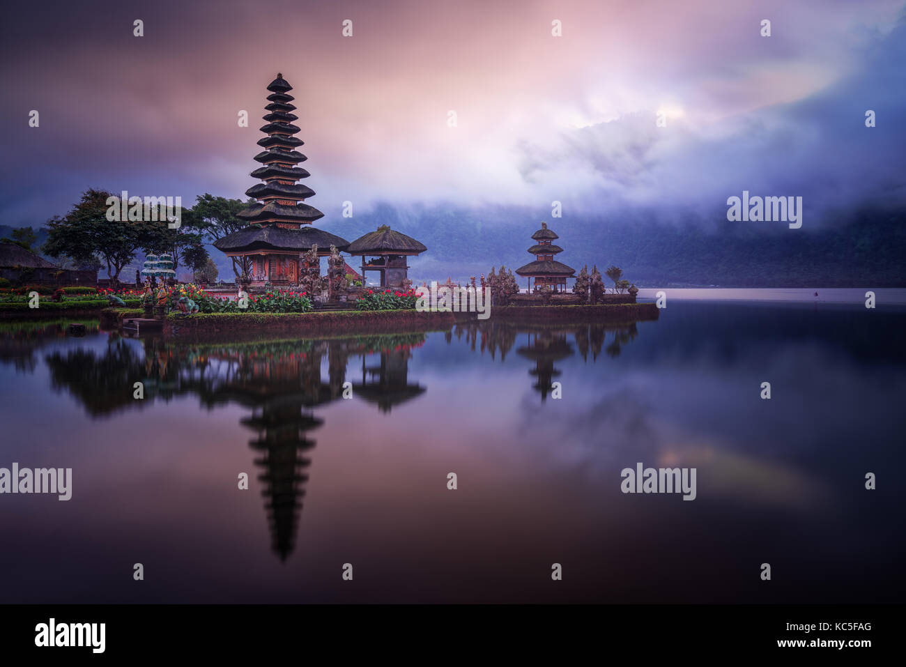 Nuageux lever du soleil dans l'eau hindou Ulun Danu Bratan temple également connu sous le nom de Pura Bratan, dans l'île indonésienne de Bali. La réflexion sur le miroir de l'eau. Banque D'Images