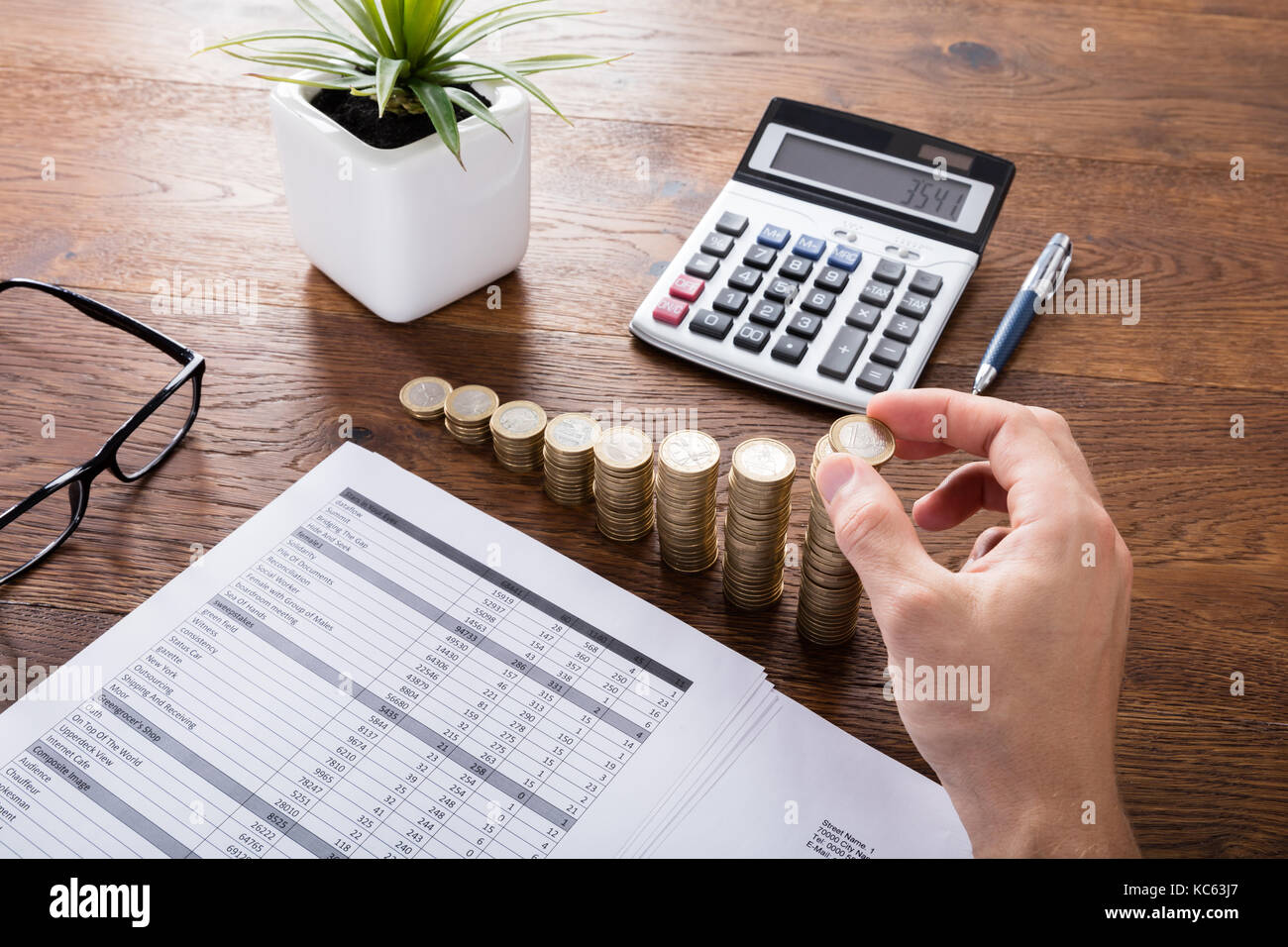 L'empilage des pièces avec personne sur calculatrice de bureau en bois. d'investissement et d'assurance concept Banque D'Images