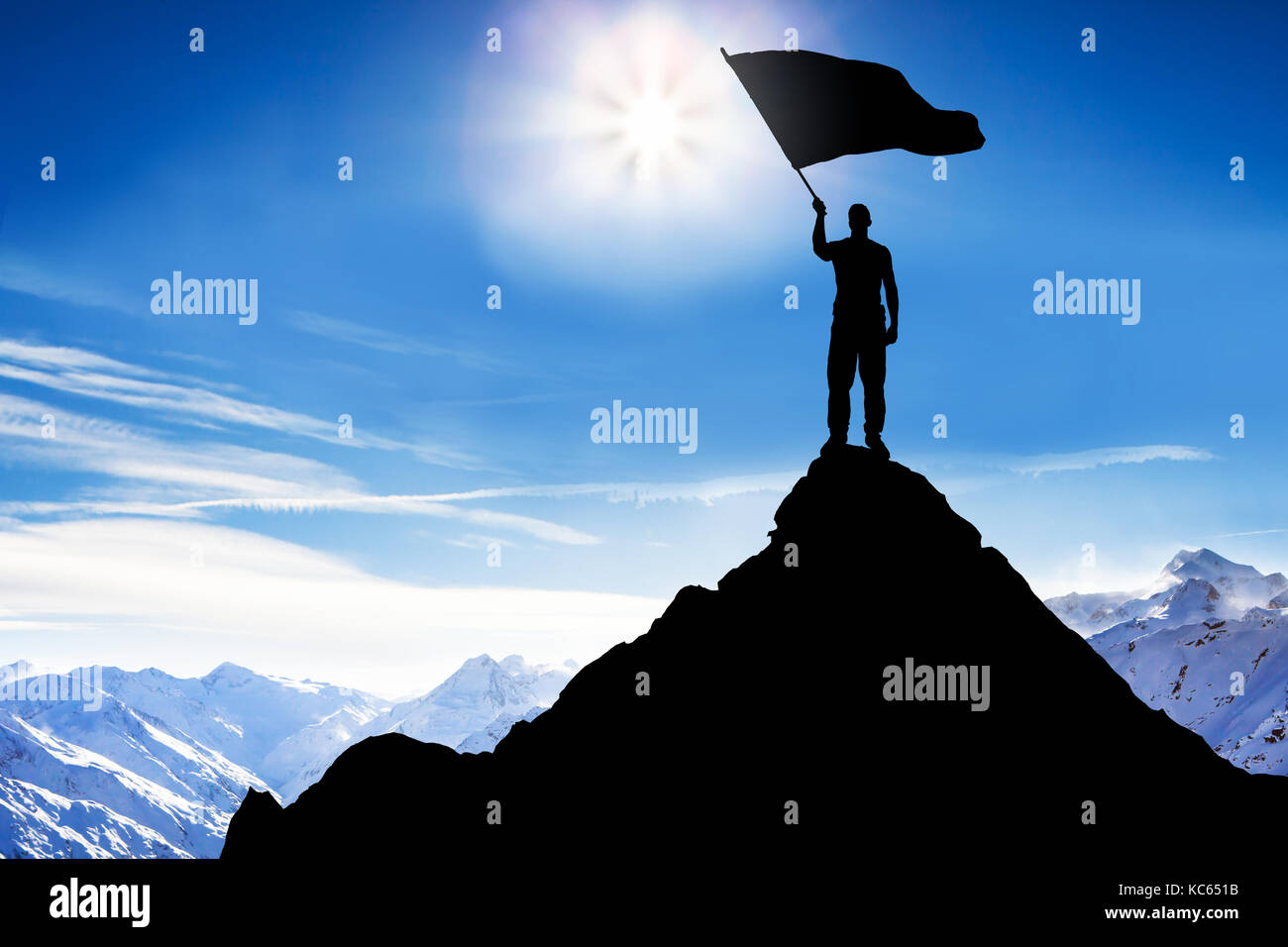 Silhouette d'un homme debout sur le sommet de la montagne Waving Flag Banque D'Images