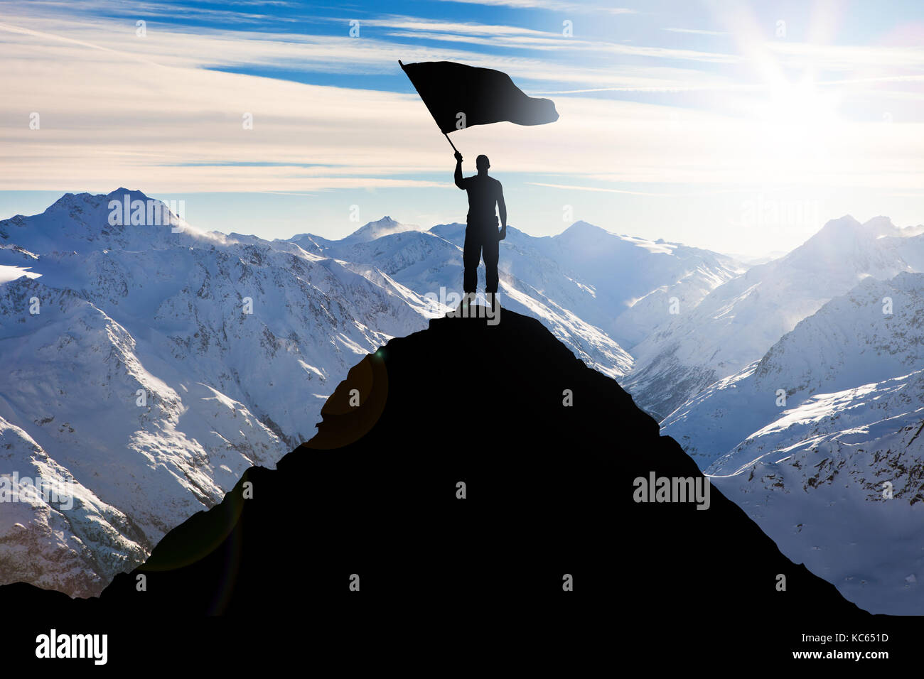 Silhouette d'un homme debout sur le sommet de la montagne Waving Flag Banque D'Images