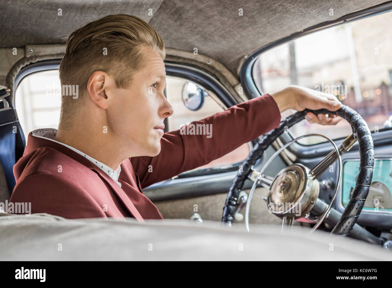 Blonde homme conduisant vintage car Banque D'Images