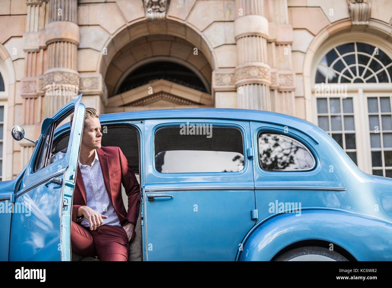 Homme élégant assis dans la voiture d'époque Banque D'Images