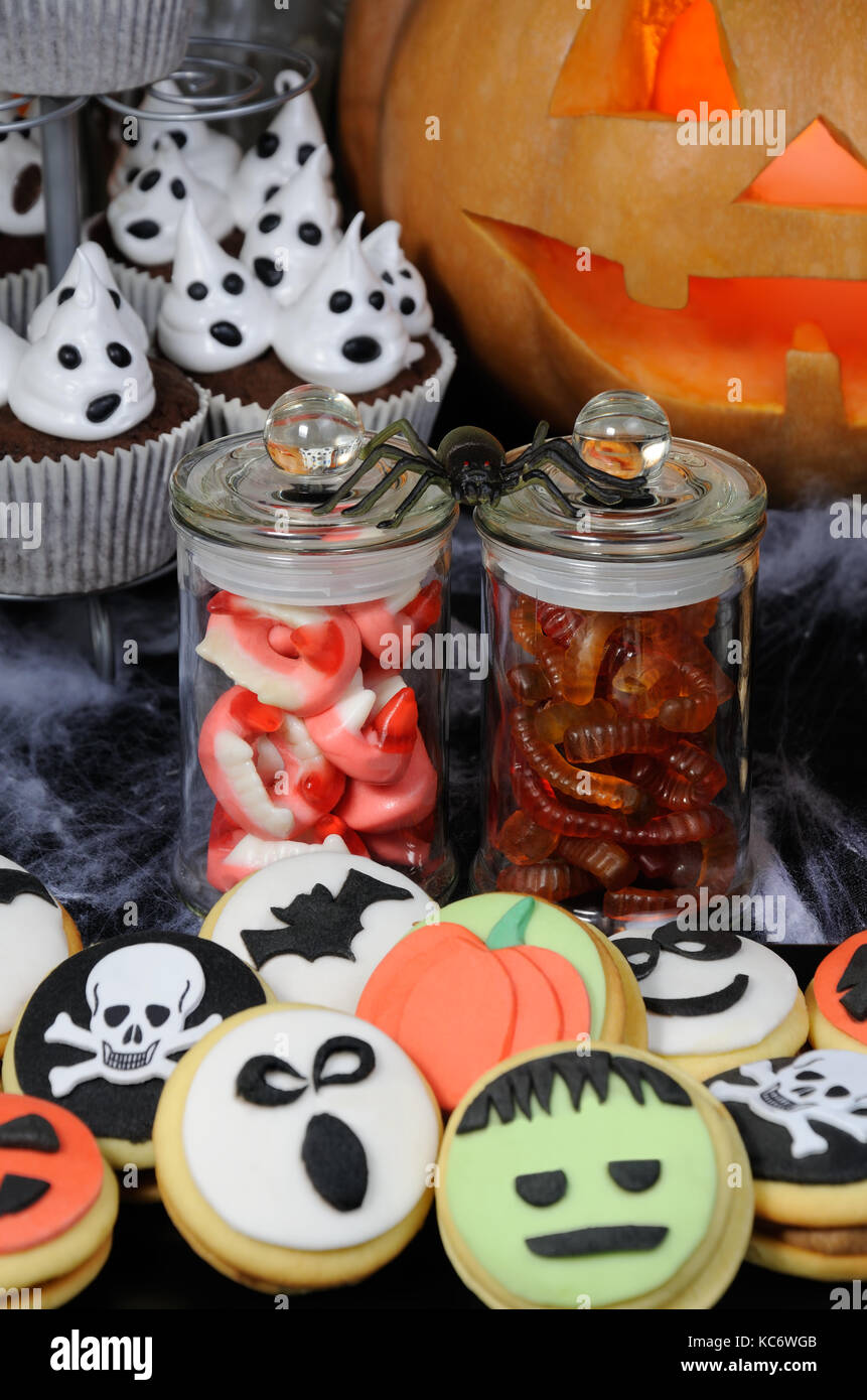 Bonbons gelée sous la forme des mâchoires et les vers dans un bocal sur une table parmi d'autres bonbons halloween Banque D'Images