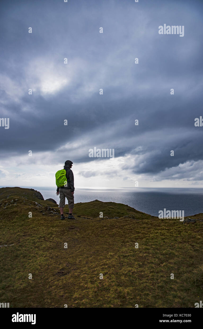 L'Irlande, comté de Donegal, randonneur regardant le long de la baie de Donegal façon sauvage de l'Atlantique Banque D'Images