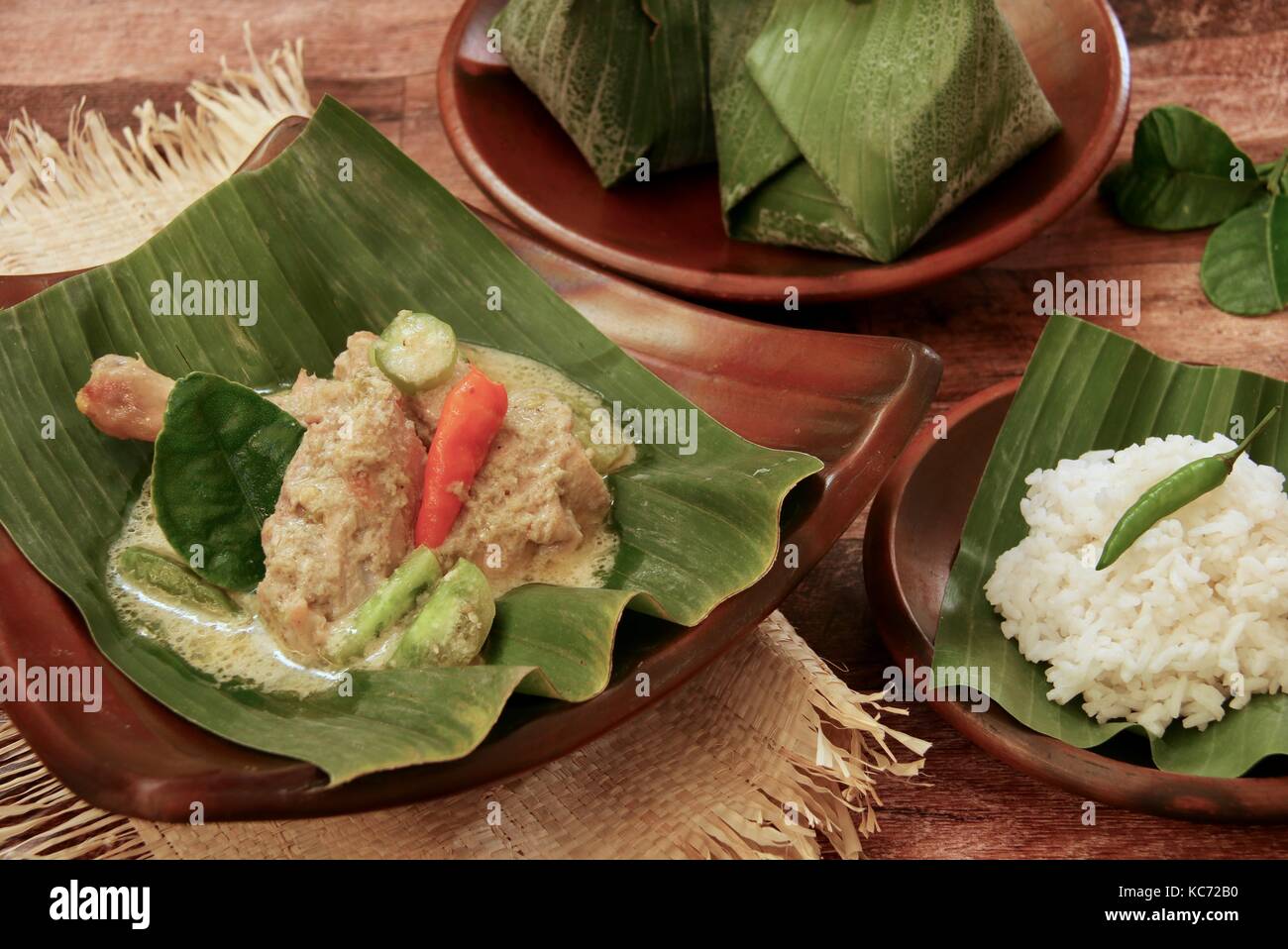Ayam Garang Asam. Poulet cuit à la javanaise au lait de coco, épices, et bilimbi en feuille de bananier de colis. Banque D'Images