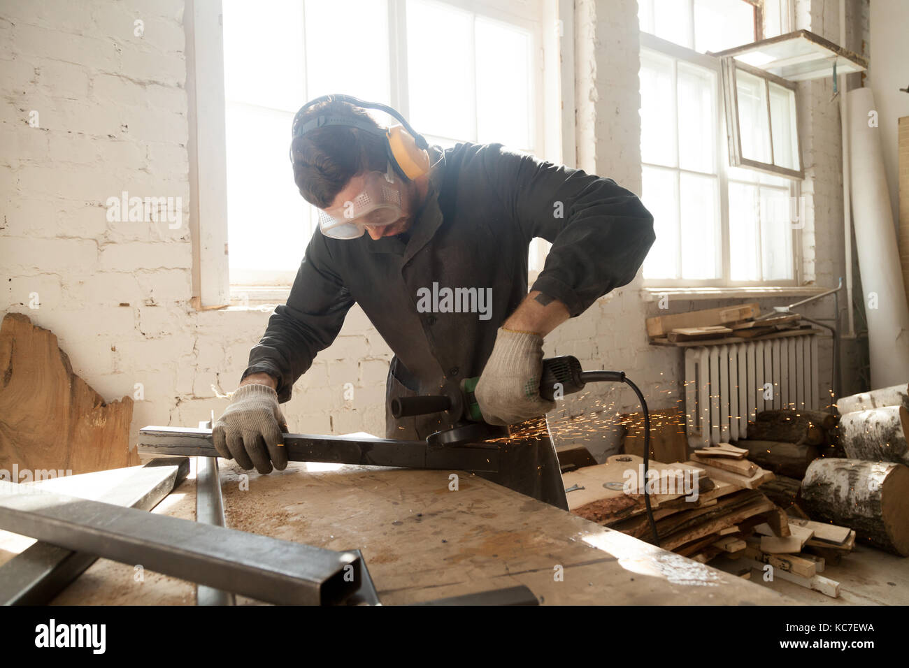 Les jeunes meules métal acier workman tuyau profil à l'atelier d'inte Banque D'Images