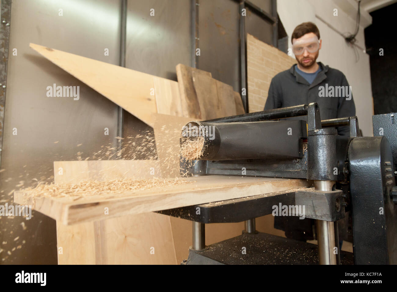 Menuisier charpentier travaillant sur l'alimentation en bois raboteuse stationnaire Banque D'Images