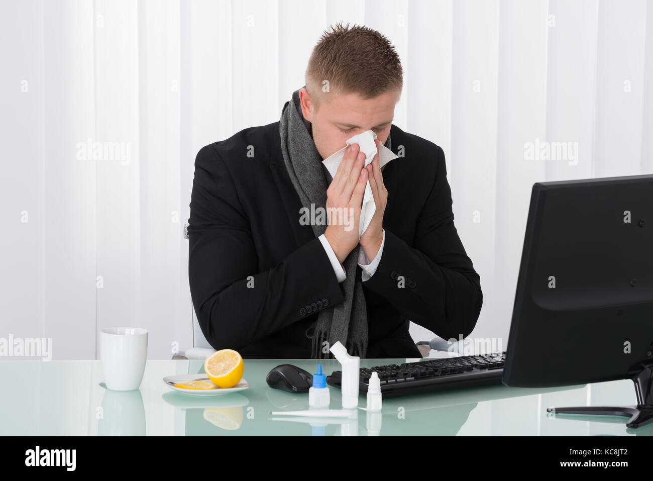 Sick Woman Blowing son nez dans Office avec des médicaments sur 24 Banque D'Images