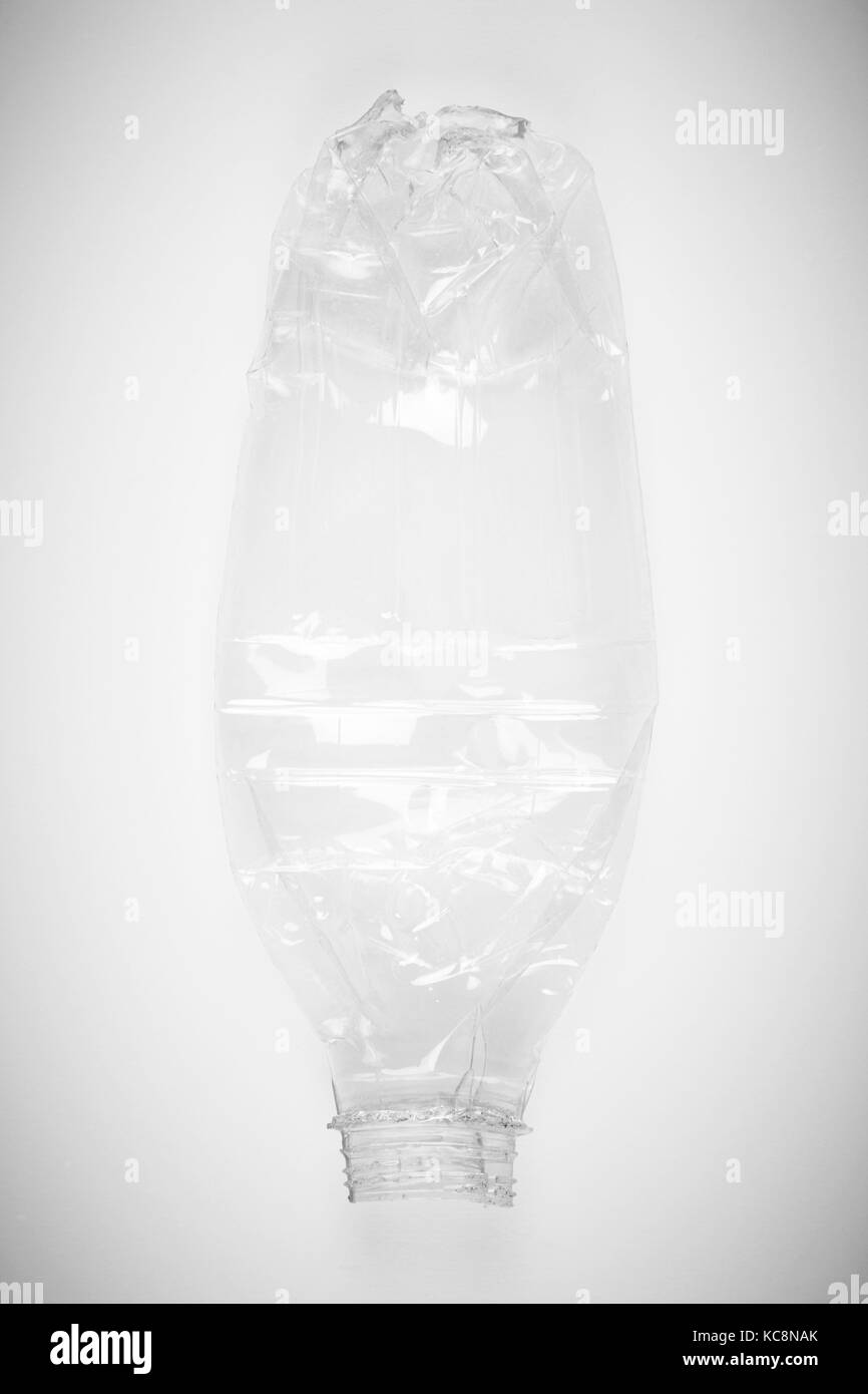 Bouteille de plastique écrasé avec un fond blanc. déchets recyclés vertical. Banque D'Images