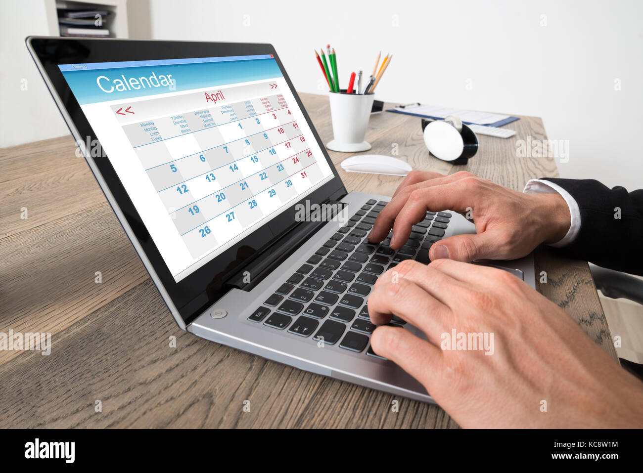 Close-up of businessman looking at calendrier sur ordinateur sur desk in office Banque D'Images