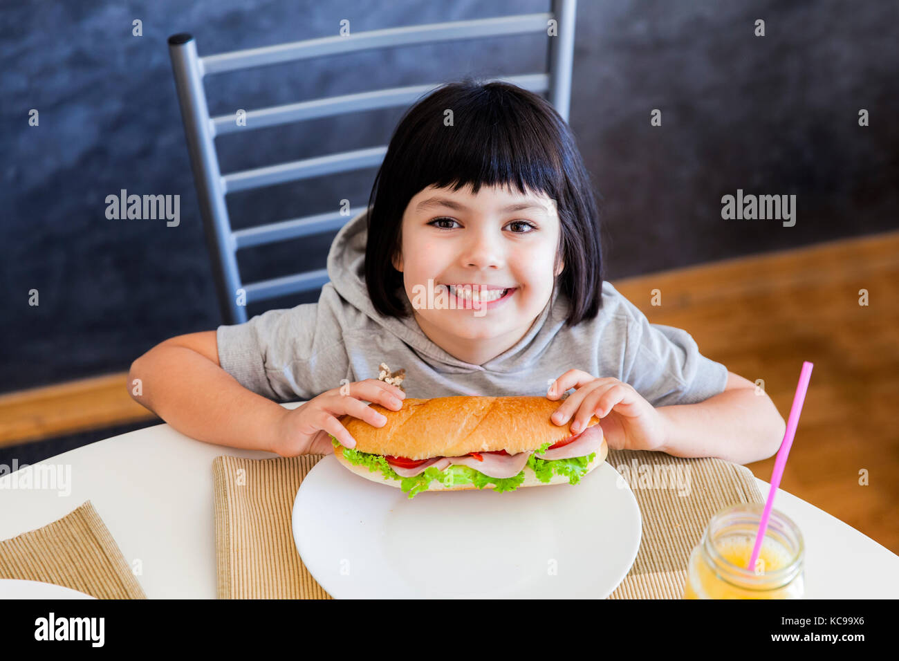Peu de cheveux cute black girl eating sandwich à la maison Banque D'Images