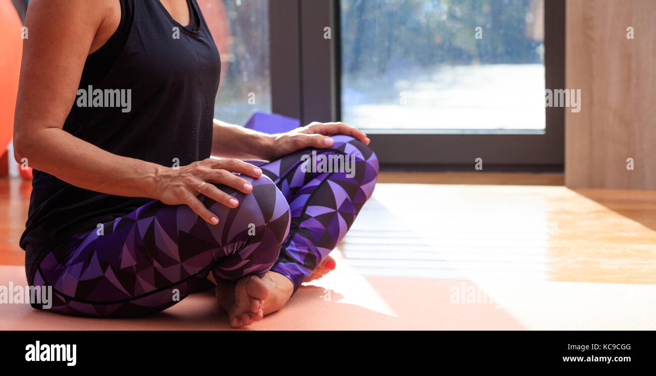 Femme dans une classe de yoga, assis sur le plancher en bois, copy space Banque D'Images