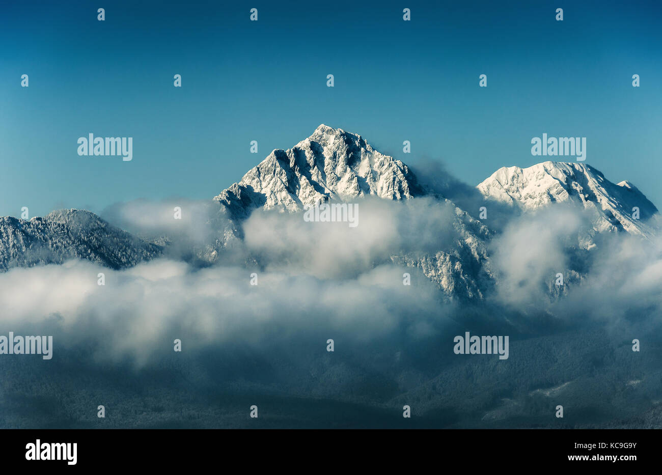 Sommet de montagne avec de la neige dans les nuages sur fond de ciel bleu, de destinations de voyage Banque D'Images