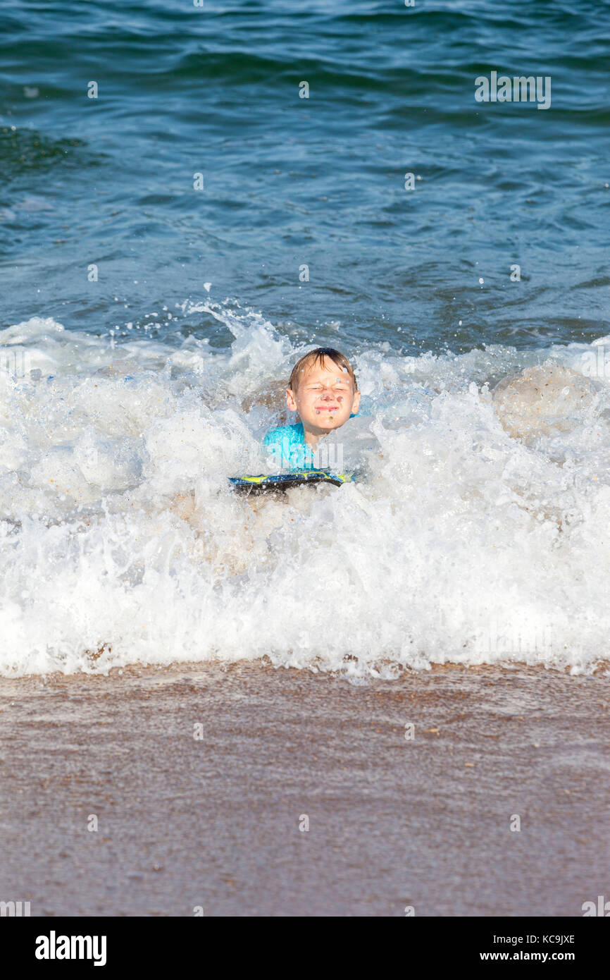 Avon, Outer Banks, Caroline du Nord, USA. Pré-adolescents dans l'Atlantique sur leurs planches de surf. Banque D'Images