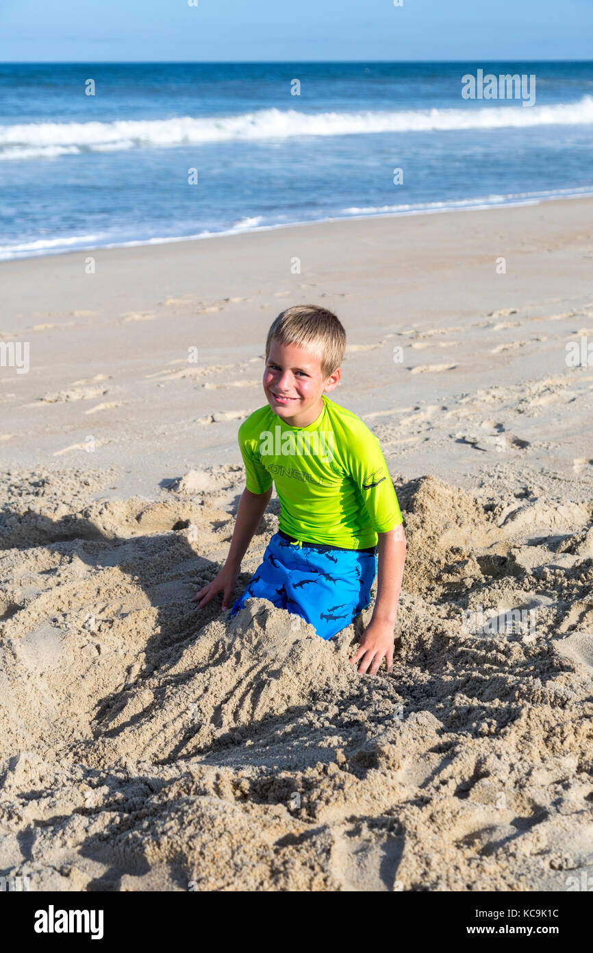 Avon, Outer Banks, Caroline du Nord, USA. Pre-adolescent jouant dans le sable sur une plage de l'Atlantique. Banque D'Images