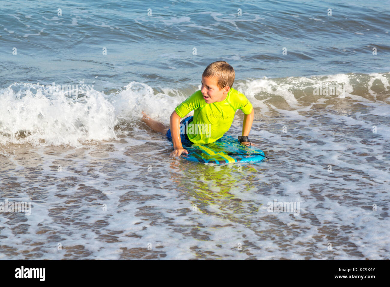Avon, Outer Banks, Caroline du Nord, USA. Jeune garçon avec son boogie board à l'atterrissage sur la plage. Banque D'Images