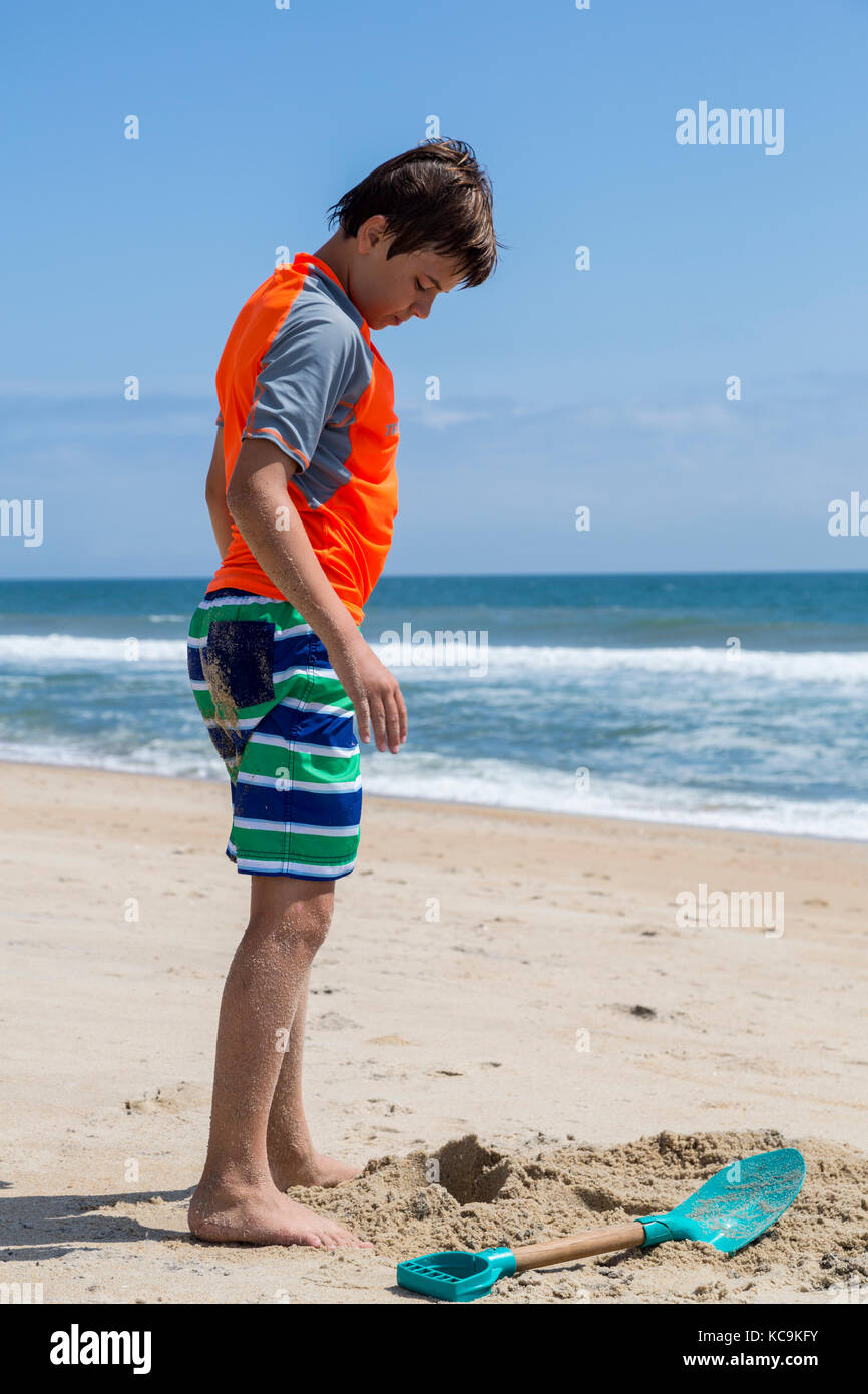 Avon, Outer Banks, Caroline du Nord, USA. Jeune garçon debout sur la plage. Banque D'Images