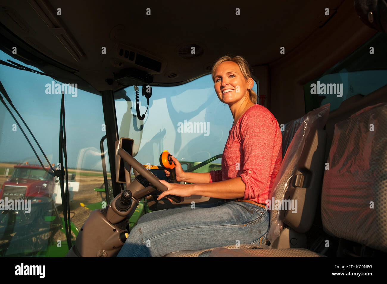 Une jeune PRODUCTRICE SE TROUVE DANS UNE MOISSONNEUSE-BATTEUSE JOHN DEERE AVANT LA RÉCOLTE DU BLÉ À LA FERME FAMILIALE PRÈS DE BRECKENRIDGE, DAKOTA DU NORD Banque D'Images