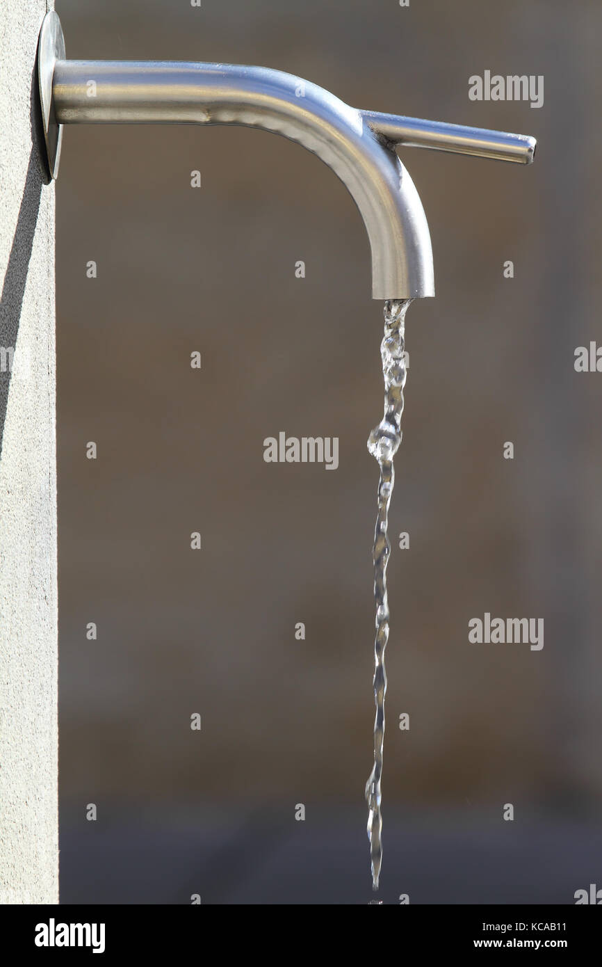L'eau qui coule d'un robinet dans une fontaine publique Banque D'Images