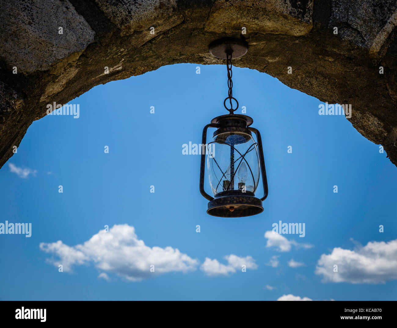 Lanterne en verre suspendue à un passage en pierre voûté Banque D'Images