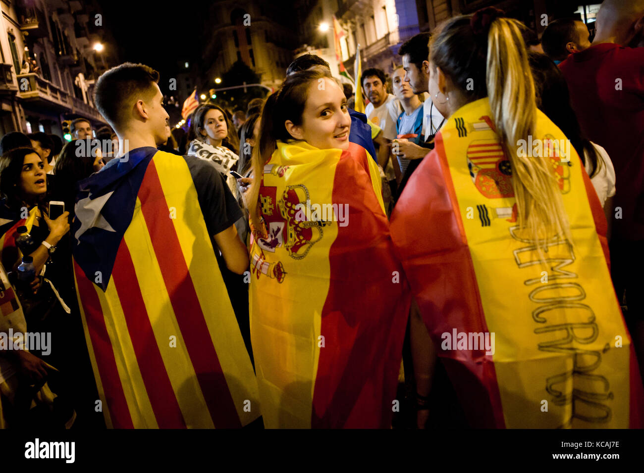 Barcelone, Catalogne, espagne. 3ème oct 2017. Les jeunes femmes enveloppés de drapeaux espagnols et d'un homme enveloppé d'un drapeau indépendantiste estelada ou prendre part ensemble à une manifestation contre la brutalité policière espagnole à Barcelone. grève générale journée avec des manifestations massives sur territoire catalan pour protester contre la brutalité par la police lors d'un référendum sur la sécession de la région de l'Espagne qui a laissé près de neuf cent de personnes blessées. crédit : jordi boixareu/zuma/Alamy fil live news Banque D'Images