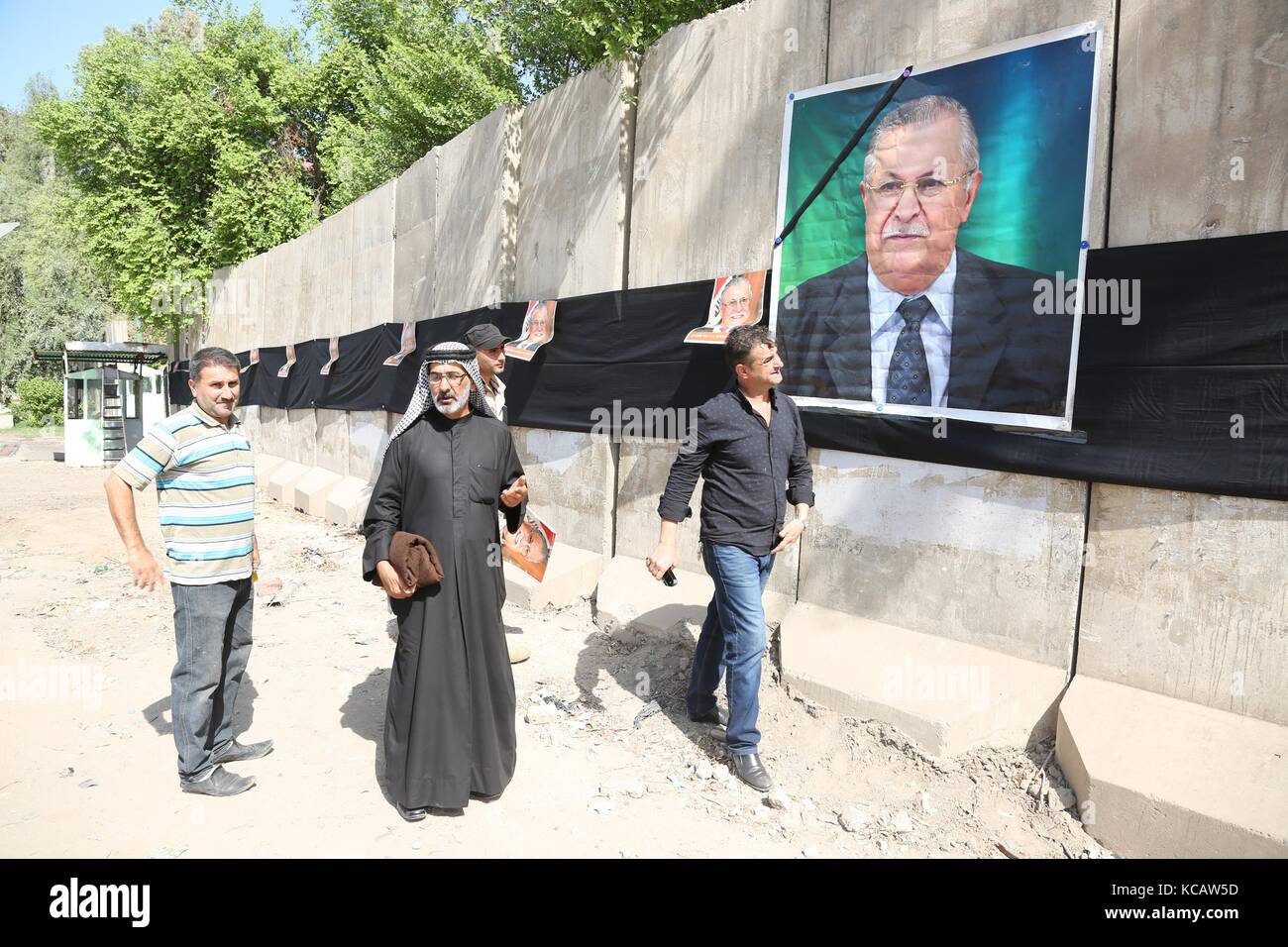 Bagdad, Irak. 4 octobre 2017. Le peuple irakien passe devant une photo de l'ancien président Jalal Talabani à Bagdad, Irak, 4 octobre 2017. L'ancien président irakien et dirigeant de l'Union patriotique du Kurdistan (UPK) Jalal Talabani est décédé mardi, a rapporté la télévision officielle irakienne. Crédit : Khalil Dawood/Xinhua/Alamy Live News Banque D'Images