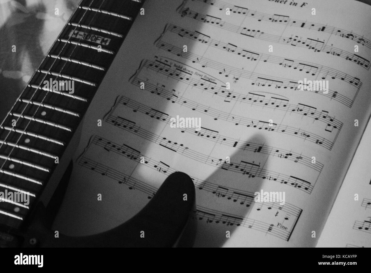Une guitare électrique instrument et un morceau de musique en feuilles et en noir et blanc carnet de notes Banque D'Images