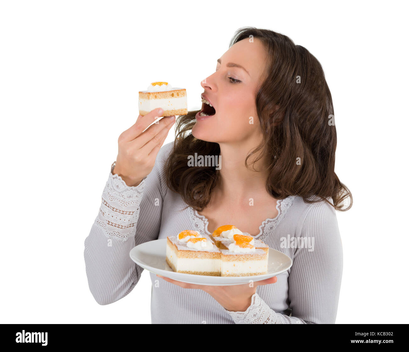 Close-up of a young woman eating un morceau de gâteau sur fond blanc Banque D'Images