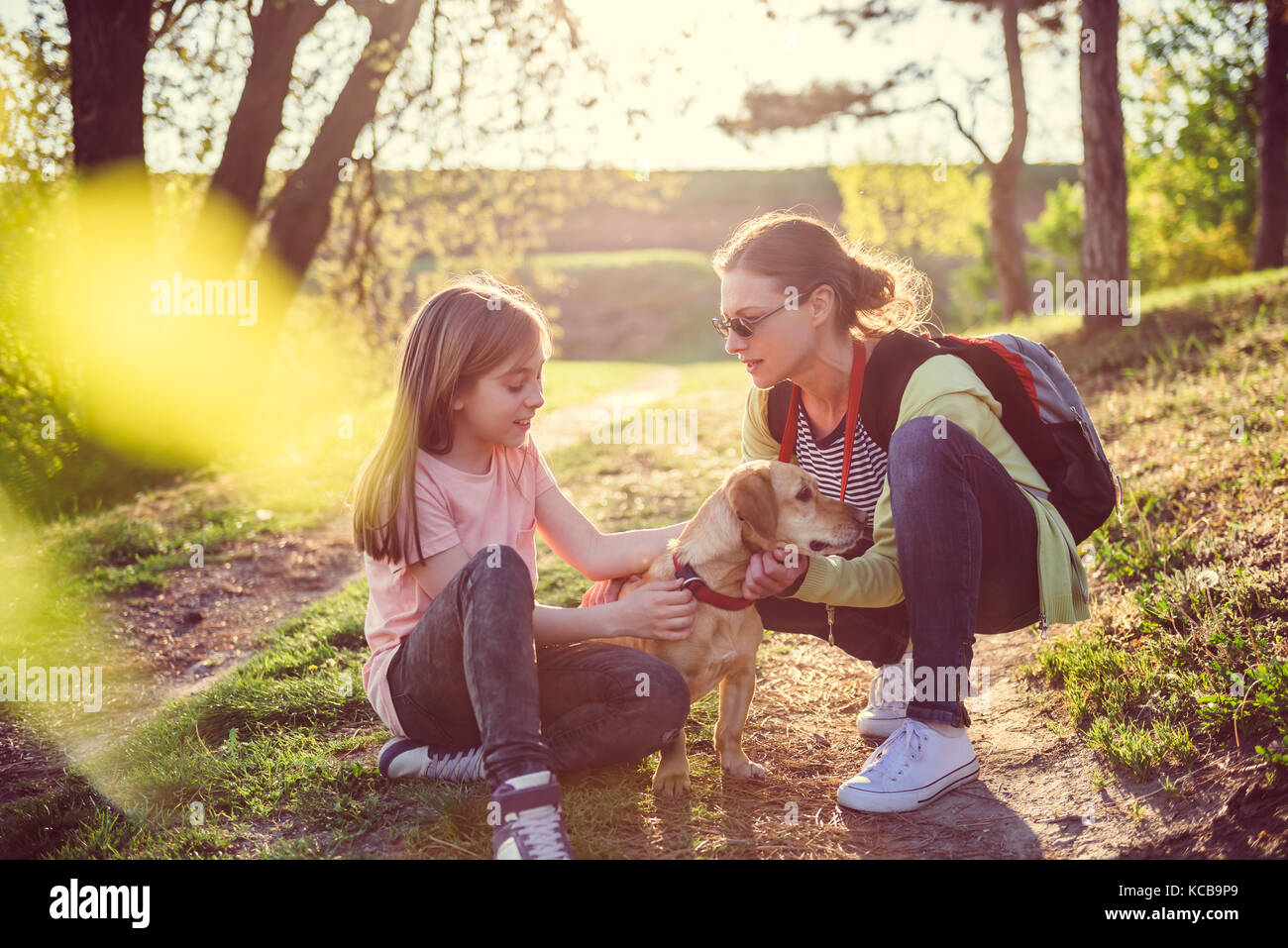 Mère et fille de flatter un chien Banque D'Images Mère et fille de flatter un chien Banque D'Images