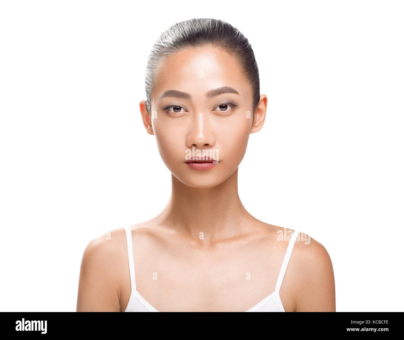 Beau modèle asiatique avec la peau bronzée parfaite et beauté visage. Jeune femme à la caméra. Studio portrait isolé sur fond blanc Banque D'Images