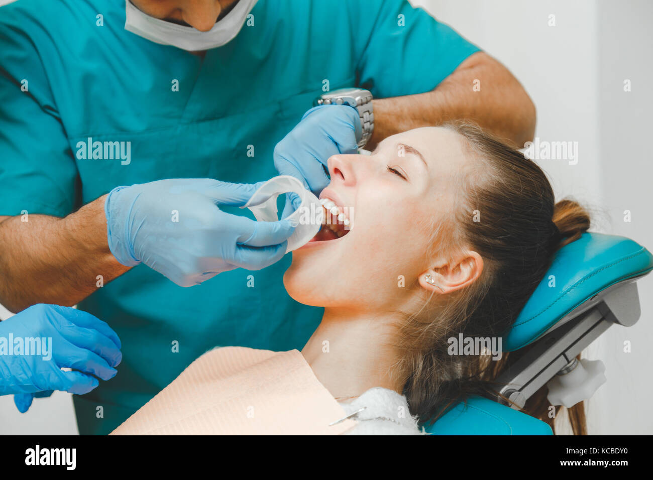 Médecin Dentiste met l'enrouleur pour le patient. Banque D'Images Médecin Dentiste met l'enrouleur pour le patient. Banque D'Images