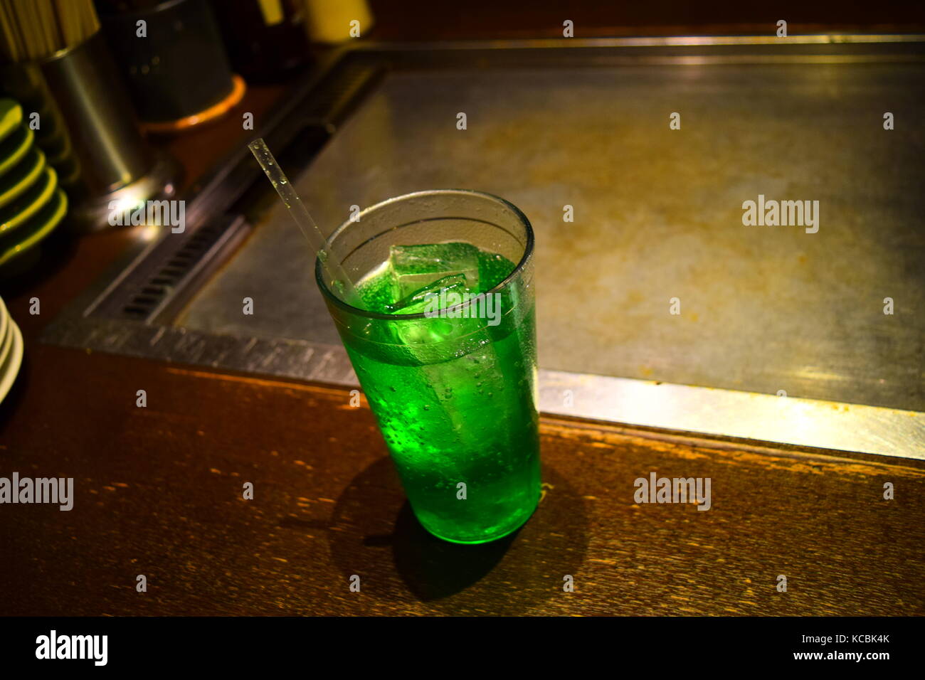 Un verre de soda vert avec une paille et des glaçons servis dans un restaurant japonais Banque D'Images